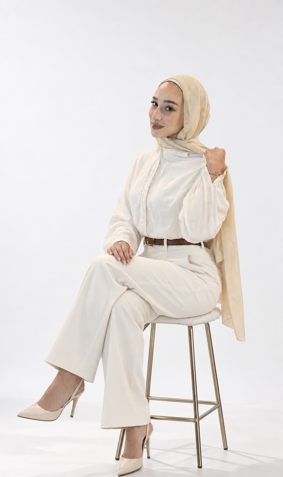 Hotaf Alawi seated in a cream outfit against a light studio background